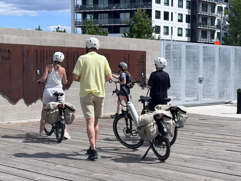E-bike tour group riding along Okanagan Lake waterfront in downtown Kelowna on a guided bicycle city highlights tour