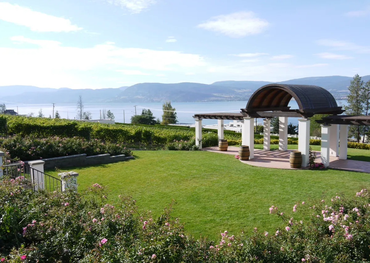 Pergola terrace and lawn at CedarCreek Estate Winery above Okanagan Lake, one of the Kelowna wineries on the Lakeshore Road bike route