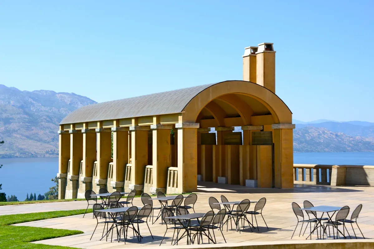 Arched loggia and courtyard tables at Mission Hill Family Estate Winery above Okanagan Lake, a West Kelowna winery reached by bike over the bridge path